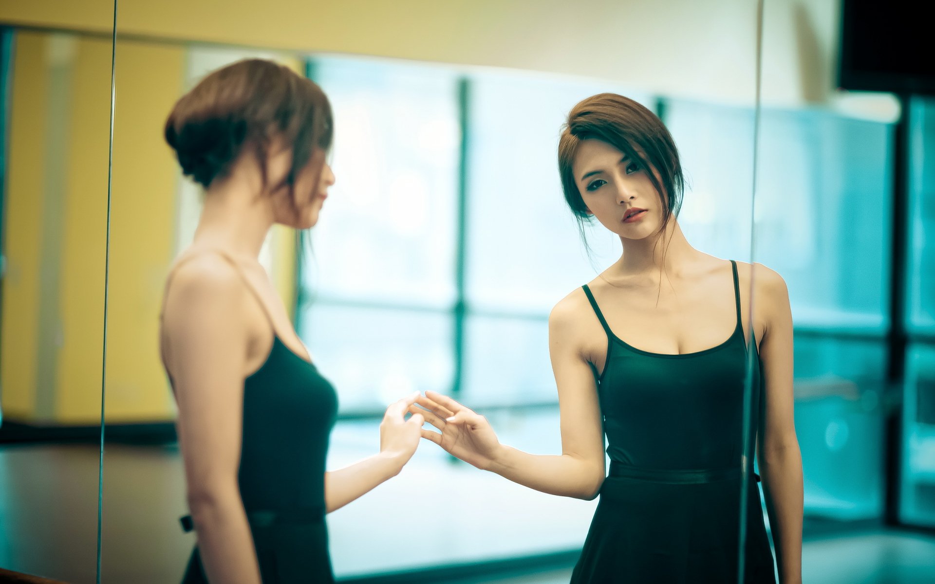 HD desktop wallpaper featuring a woman in an introspective mood, standing in front of a large mirror with a soft, out-of-focus background.