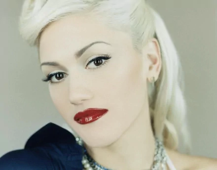 Close-up HD PC desktop wallpaper of Gwen Stefani with platinum blonde hair, striking makeup, and bold red lipstick, showcasing her signature music style.