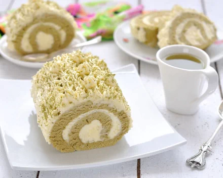 A delectable roll cake topped with creamy frosting sits on a plate, accompanied by a cup of coffee, complemented by other dessert slices in the background. A delightful food-themed wallpaper.