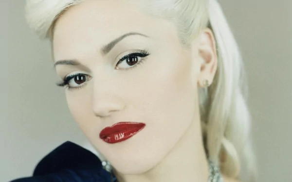 Close-up HD PC desktop wallpaper of Gwen Stefani with platinum blonde hair, striking makeup, and bold red lipstick, showcasing her signature music style.