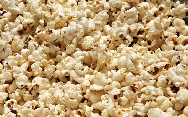 A close-up view of fluffy, buttery popcorn fills the frame, creating an inviting and delicious backdrop for a HD PC desktop wallpaper.