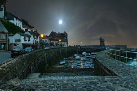HD desktop wallpaper of a peaceful man-made harbor in a small town at night, illuminated by moonlight and street lamps along cobblestone pathways.