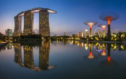 Stunning view of Marina Bay Sands in Singapore, featuring its iconic architecture reflected in the water at dusk, surrounded by vibrant man-made structures. A captivating desktop wallpaper.
