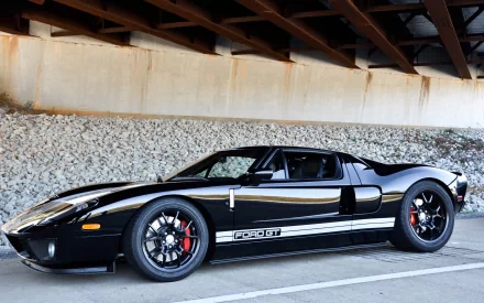 A sleek black Ford GT parked under an overpass, showcasing its aerodynamic design and striking features, creating a dynamic HD desktop wallpaper background.