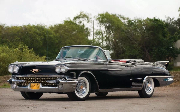 HD desktop wallpaper featuring a sleek black 1958 Cadillac Eldorado Brougham convertible parked outdoors against a backdrop of trees.