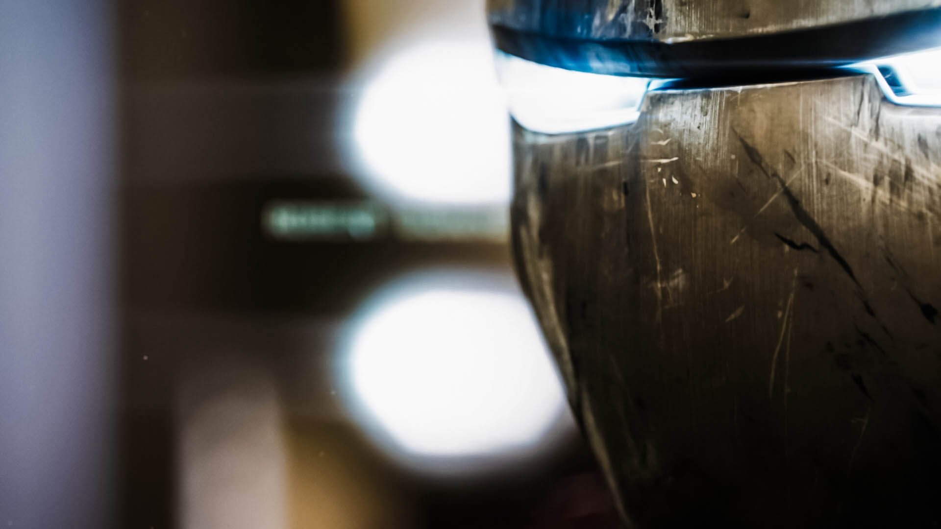 HD PC desktop wallpaper featuring a close-up of Iron Man's helmet from the movie, highlighting its metallic texture and illuminated eye slit.