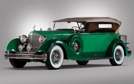 HD desktop wallpaper featuring a classic green Packard Twelve vintage vehicle with whitewall tires and a tan convertible roof against a neutral background.