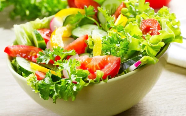 HD PC desktop wallpaper featuring a vibrant, fresh salad with lettuce, tomatoes, cucumbers, and herbs, showcasing colorful and healthy food.