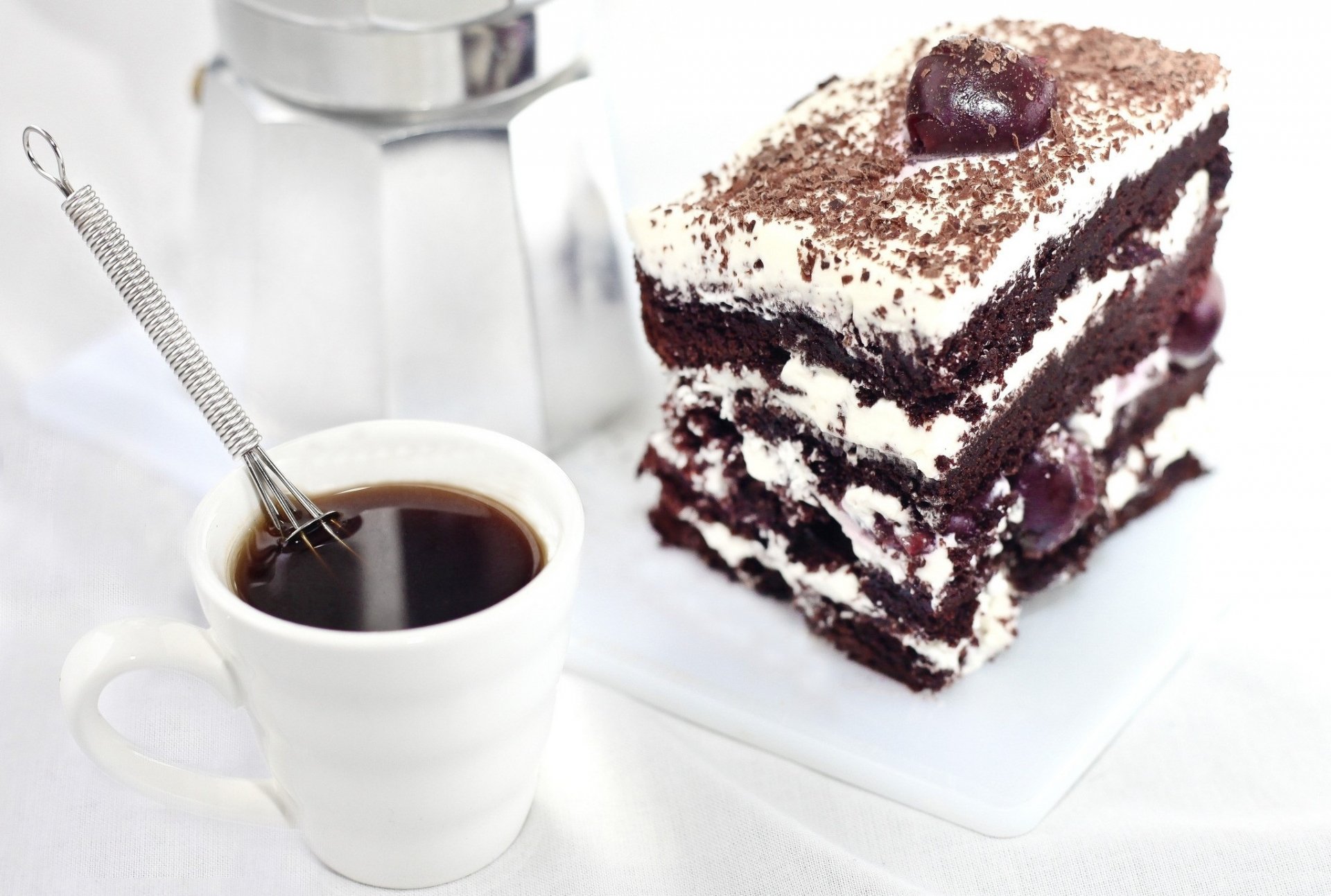 HD desktop wallpaper featuring a rich chocolate cake slice topped with cream and a cherry, accompanied by a cup of black coffee, showcasing dessert and sweets.