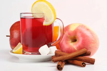 A clear glass mug of red tea with a lemon slice, accompanied by apples, cinnamon sticks, and sugar cubes, displayed in vibrant 4K Ultra HD detail as a PC desktop wallpaper.