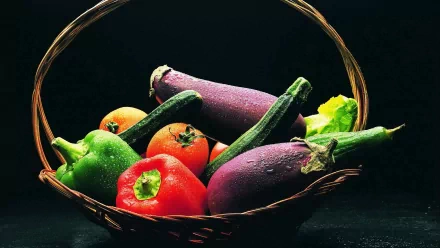 HD PC desktop wallpaper showing a basket of fresh vegetables, including eggplants, tomatoes, bell peppers, and okra, against a dark background.