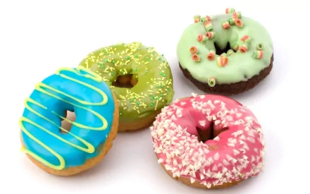 HD desktop wallpaper featuring four colorful doughnuts with blue, green, mint, and pink icing decorated with sprinkles and toppings on a white background.
