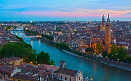 HD desktop wallpaper showcasing a man-made town with a river winding through historic buildings under a colorful evening sky.