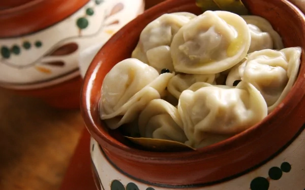 A close-up of steaming dumplings in a traditional clay pot, highlighting delicious pasta. This HD desktop wallpaper captures the essence of a comforting meal.