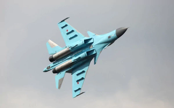 HD desktop wallpaper featuring a military Sukhoi Su-34 fighter jet soaring through a cloudy sky.