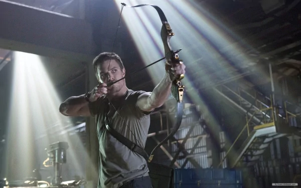 Stephen Amell as Green Arrow draws his bow in a dramatic scene from the TV show Arrow, captured in an HD PC desktop wallpaper featuring striking lighting and intensity.