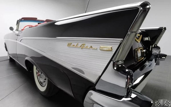 Rear three-quarter view of a 1957 Chevrolet Bel Air vehicle, chrome fins and tail emblem on a black-and-white convertible, shown as a 2K Quad HD PC desktop wallpaper/background.