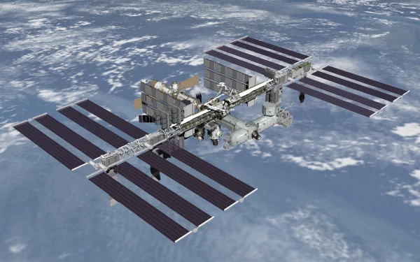 A high-definition image of the International Space Station (ISS) orbiting Earth, showcasing its solar panels and intricate structure against a backdrop of space.