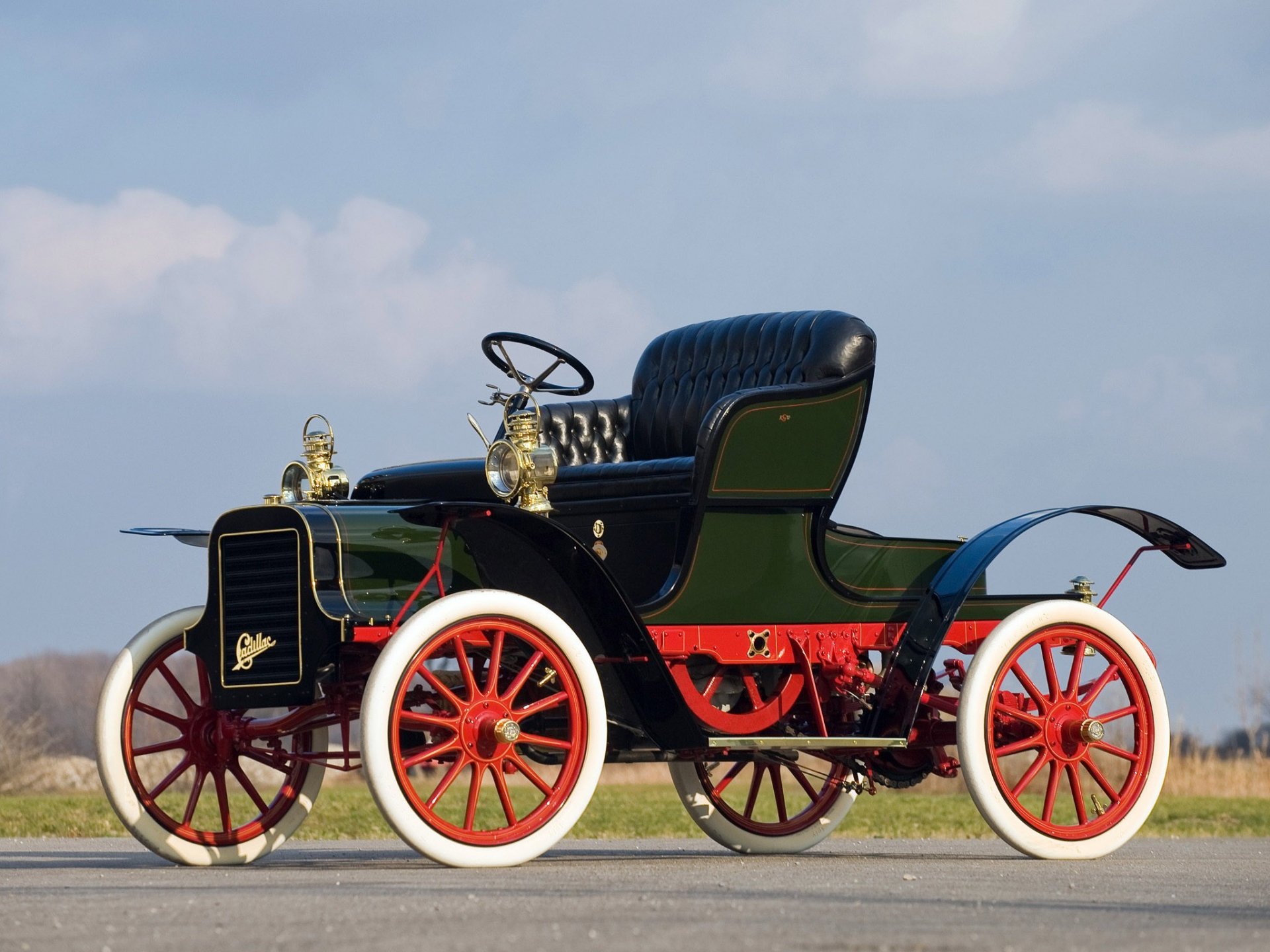1908 Cadillac Model S vintage vehicle with red spoked wheels and black leather seat, set against a clear sky background as an HD PC desktop wallpaper.