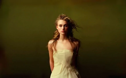 HD desktop wallpaper featuring celebrity Keira Knightley in a light dress, standing against a muted green background.