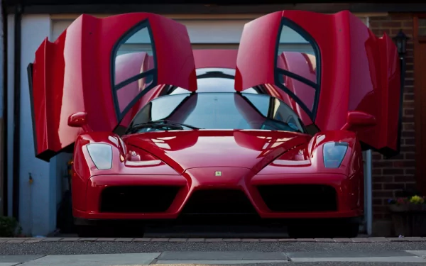 A striking red Ferrari Enzo with its iconic doors open, set against a clean backdrop, features in this 4K Ultra HD desktop wallpaper and background.