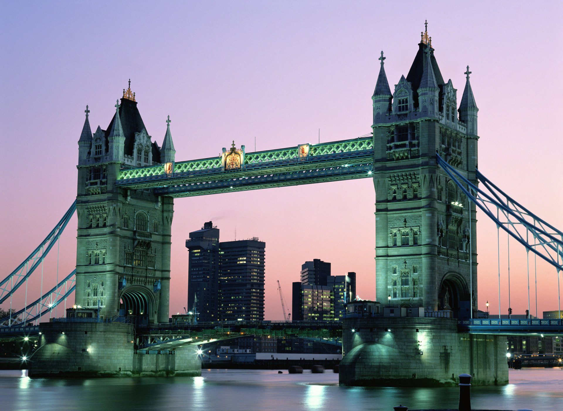 HD desktop wallpaper featuring London’s iconic man-made Tower Bridge illuminated against a twilight sky.