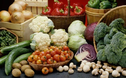 A vibrant array of fresh vegetables, including broccoli, cauliflower, tomatoes, and bell peppers, arranged beautifully on a desktop wallpaper background.