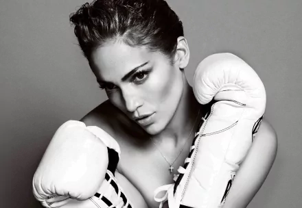 Black and white HD desktop wallpaper of celebrity Jennifer Lopez wearing boxing gloves, striking a fierce and confident pose.