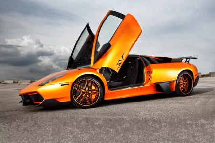 HD desktop wallpaper featuring a vibrant orange Lamborghini Murcielago with its scissor doors open, set against a dramatic, cloudy sky background.