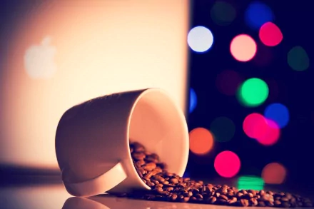 A stylish HD desktop wallpaper featuring a spilled coffee cup with beans, set against a backdrop of colorful bokeh lights, creating a warm, inviting atmosphere.