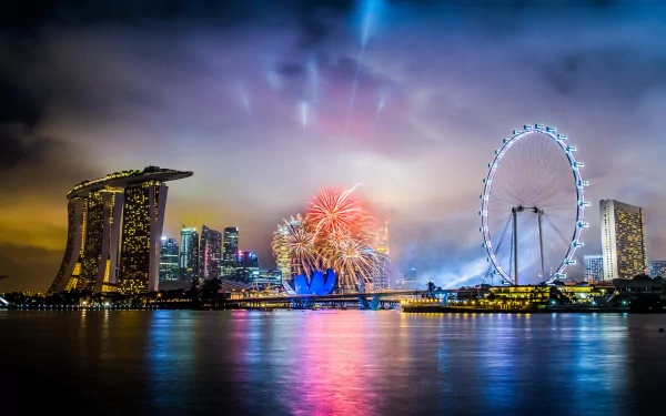 HD desktop wallpaper of Singapore’s man-made skyline at night featuring fireworks over Marina Bay, with the iconic Singapore Flyer and Marina Bay Sands illuminated.