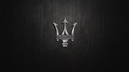An elegant HD wallpaper featuring the iconic Maserati logo against a dark, textured background, showcasing the brand's luxurious and sporty essence.