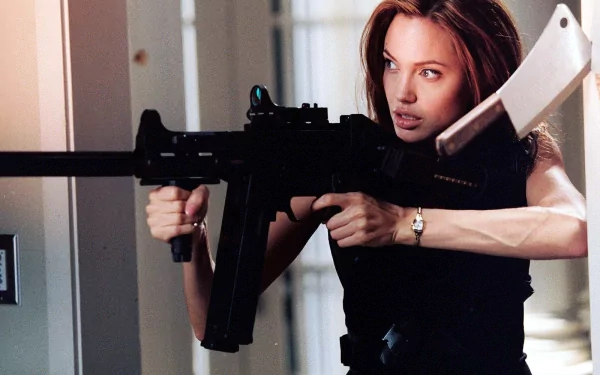 Angelina Jolie in a dynamic pose with a firearm, showcasing her role in the movie *Mr. & Mrs. Smith*. This HD wallpaper captures an intense moment from the film.