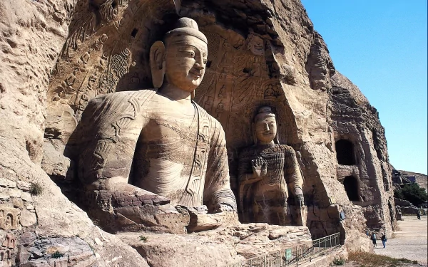 HD PC desktop wallpaper showcasing the intricately carved religious statues at Yungang Grottoes against a clear blue sky.