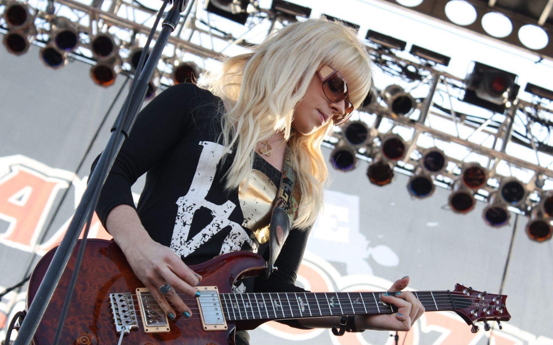 HD PC desktop wallpaper of Orianthi playing guitar on stage, capturing a dynamic music performance moment.