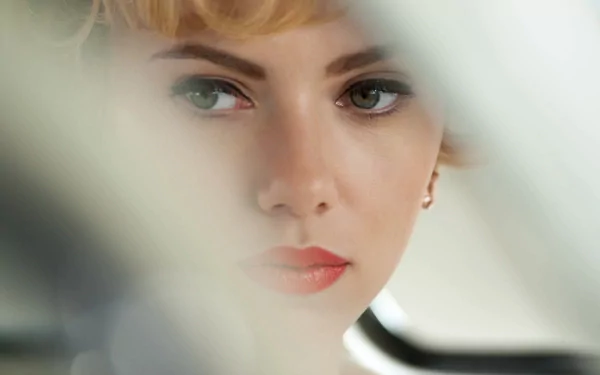 Close-up of a blonde woman with expressive eyes and red lips, cinematic Hitchcock movie atmosphere — 2K Quad HD PC desktop wallpaper/background.
