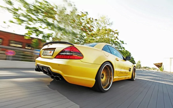 Yellow Mercedes-Benz SL 55 AMG captured in motion on a sunlit road, featured as a high-definition PC desktop wallpaper.