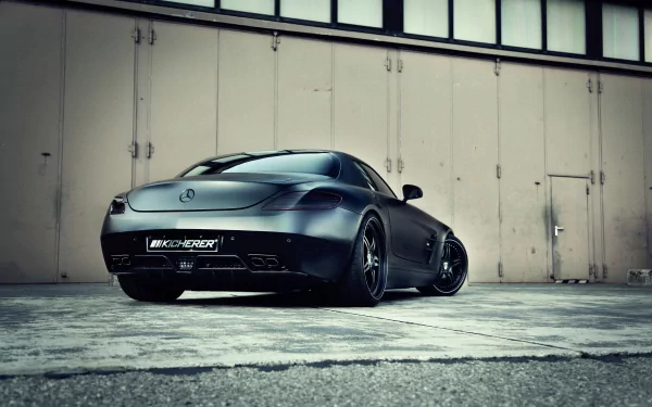 HD wallpaper showcasing a sleek Kicherer Mercedes-Benz SLS AMG with distinctive gull-wing doors in an industrial setting.