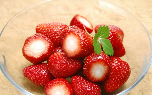 A close-up of fresh, ripe strawberries in a glass bowl, captured in high definition for a vibrant PC desktop wallpaper and background.