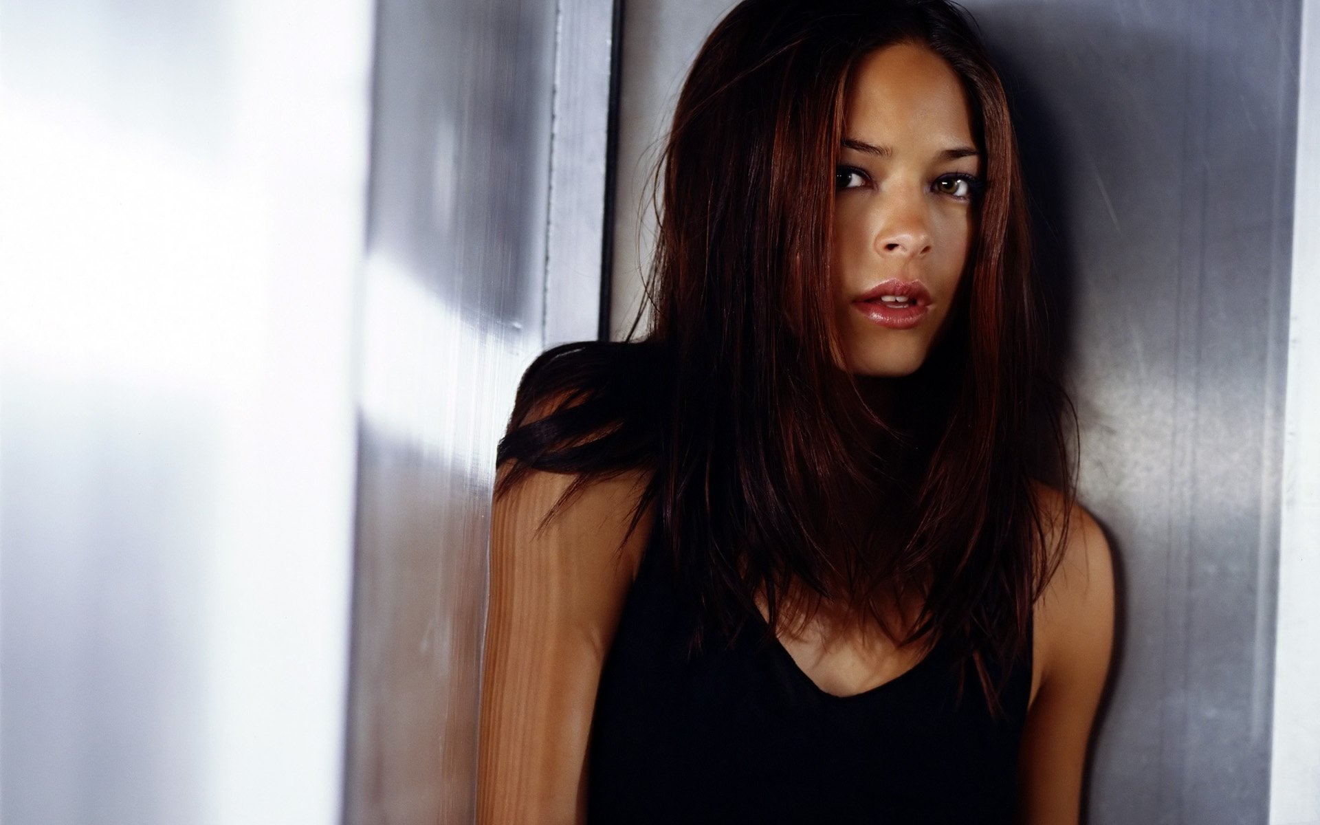 A striking HD wallpaper featuring the celebrity Kristin Kreuk, captured in a contemplative moment, showcasing her natural beauty and expressive gaze.