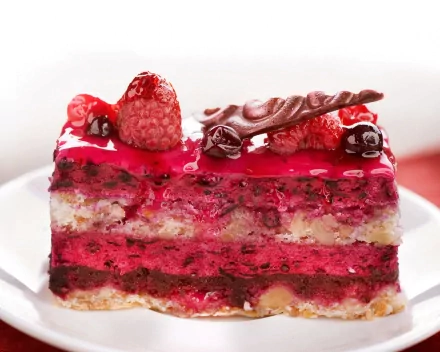 A delicious slice of layered cake topped with raspberries and chocolate, showcasing vibrant colors and textures, serves as an enticing HD desktop wallpaper and background.