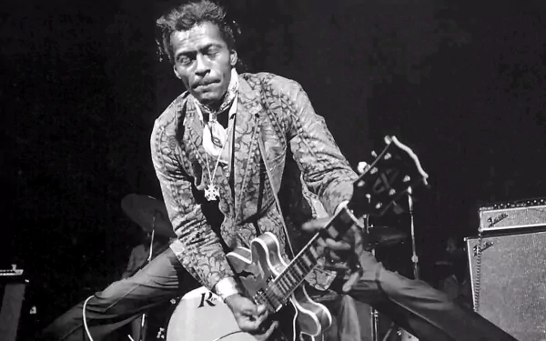HD PC desktop wallpaper: black-and-white shot of an iconic rock ’n’ roll guitarist mid-performance, energetic pose with electric guitar and vintage amp.