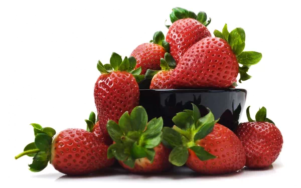 A vibrant HD desktop wallpaper featuring a pile of fresh strawberries arranged around a black bowl, showcasing their bright red color and green leaves, symbolizing freshness and abundance.