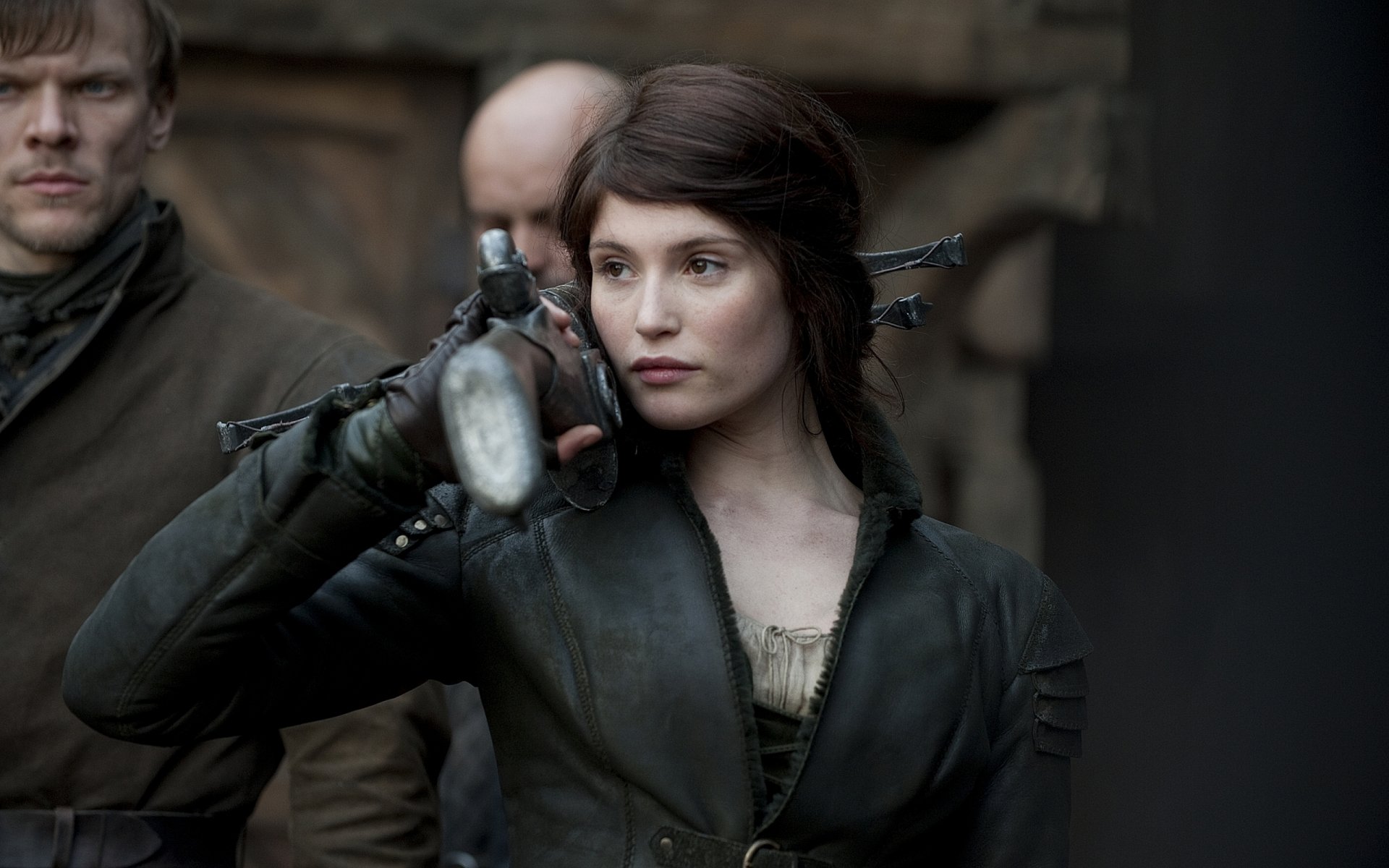 HD PC desktop wallpaper from the movie Hansel & Gretel: Witch Hunters featuring a focused woman holding a crossbow in a dark, medieval setting.