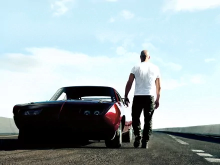 Vin Diesel as Dominic Toretto from Fast & Furious 6 walks next to a muscle car on a deserted road. High-definition desktop wallpaper and background.