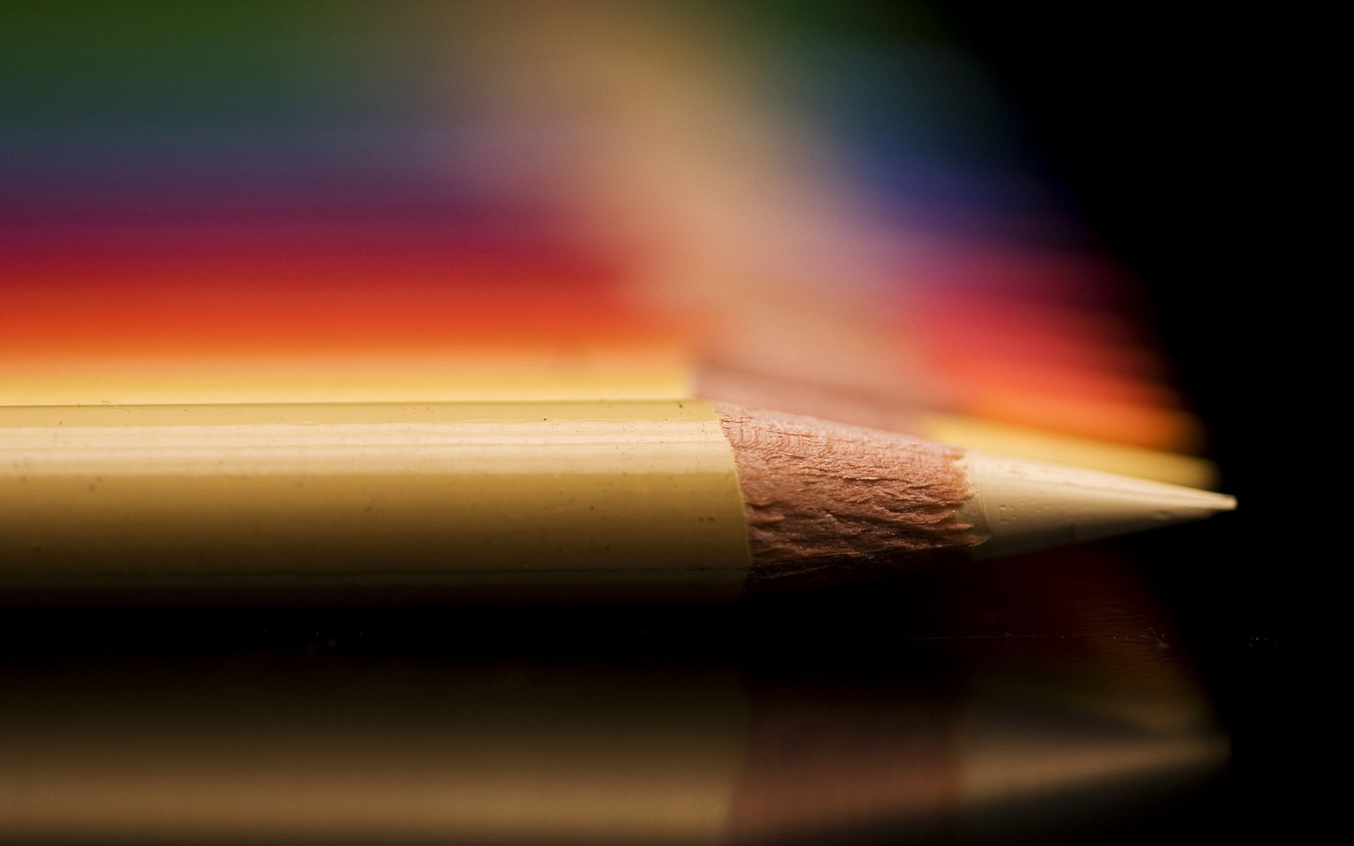 Close-up photography of a sharpened pencil tip with a blurred colorful background, presented as an HD PC desktop wallpaper.