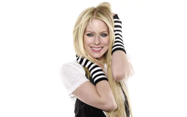 A vibrant HD wallpaper featuring Avril Lavigne, showcasing her playful style with striped arm warmers and a cheerful smile against a clean background.