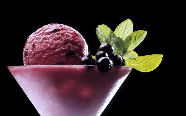 HD wallpaper of a delicious purple ice cream scoop in a frosted glass, garnished with fresh berries and mint leaves against a black background.
