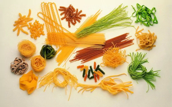 HD PC desktop wallpaper featuring an assortment of various uncooked pasta types artistically arranged on a light background.