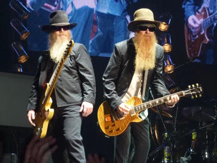 HD PC desktop wallpaper featuring ZZ Top performing live on stage, showcasing band members with iconic beards and guitars under vibrant concert lighting.